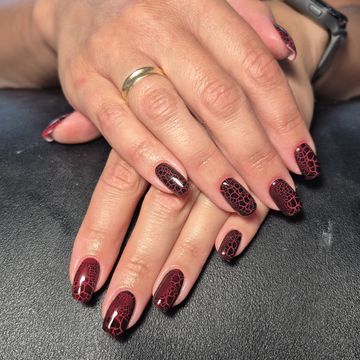 Bordowy manicure z delikatnym czarnym zdobieniem wykonany w Dermline